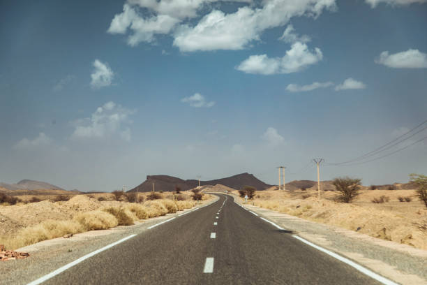istock Journey Through the Arid Moroccan Landscape Along the Lonely Highway Under a Vibrant Sky 2174160313