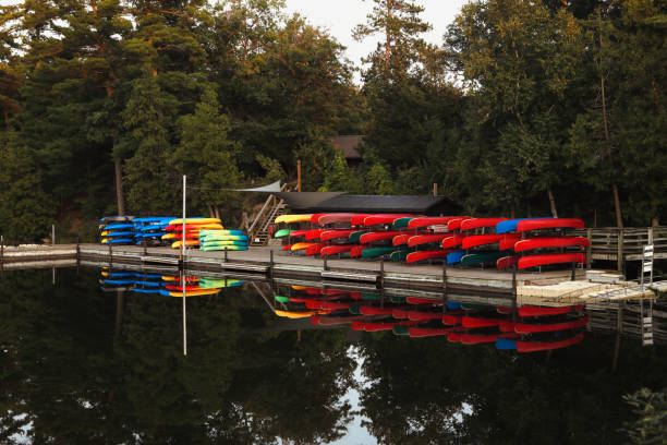 A canoe and kayak rental shop along the river. Mirrored reflection in the still water.
