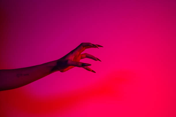 istock A terrifying witch's hand with long red nails, resembling a demon or vampire. Its gnarled appearance hints at monstrous origins, resembling an alien or ghostly entity,with zombie-like decayed skin. 2174164455