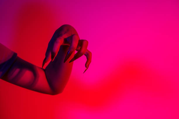 istock A terrifying witch's hand with long red nails, resembling a demon or vampire. Its gnarled appearance hints at monstrous origins, resembling an alien or ghostly entity,with zombie-like decayed skin. 2174164469