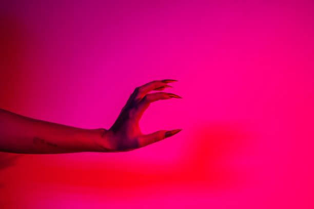 istock A terrifying witch's hand with long red nails, resembling a demon or vampire. Its gnarled appearance hints at monstrous origins, resembling an alien or ghostly entity,with zombie-like decayed skin. 2174164495