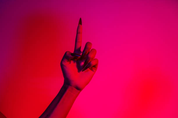 A terrifying witch's hand with long red nails, resembling a demon or vampire. Its gnarled appearance hints at monstrous origins, resembling an alien or ghostly entity,with zombie-like decayed skin.