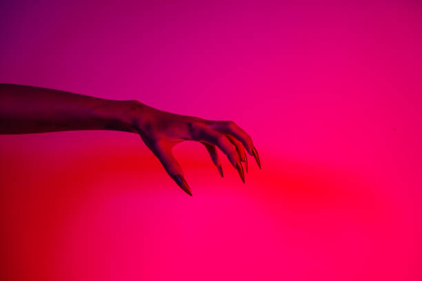 istock A terrifying witch's hand with long red nails, resembling a demon or vampire. Its gnarled appearance hints at monstrous origins, resembling an alien or ghostly entity,with zombie-like decayed skin. 2174164501