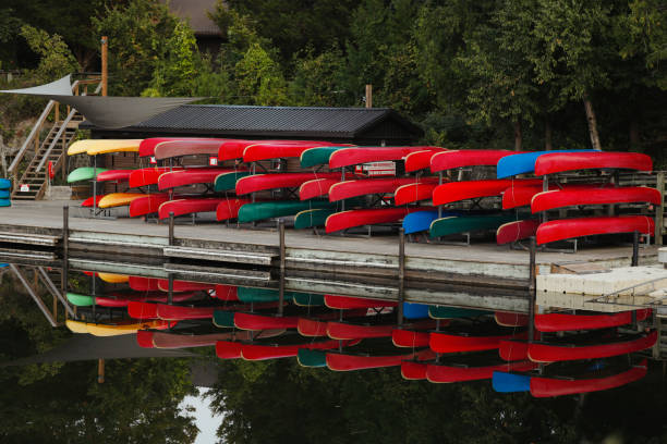 A canoe and kayak rental shop along the river. Mirrored reflection in the still water.