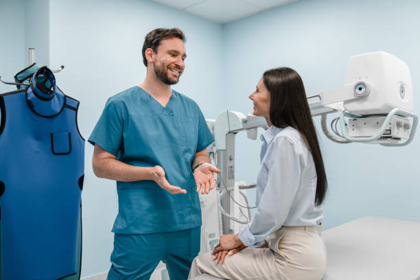 istock Doctor talking with female patient woman before X-ray scan procedure. Patient explaining symptoms to medicine worker . Specialist making notes about patient well being. 2174166785