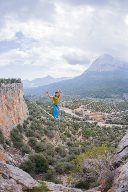 istock A tightrope walker walks along a cable stretched over a canyon. 2174168020
