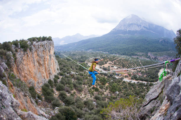 istock A tightrope walker walks along a cable stretched over a canyon. 2174168023
