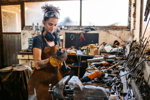 istock Young Woman Working On A Thin Metal Rod In A Workshop 2174168892
