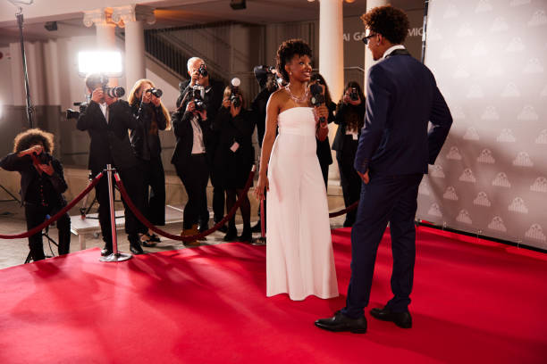 istock A movie star stops on the red carpet before the step and repeats the wall, ready for an interview with a reporter. 2174169832
