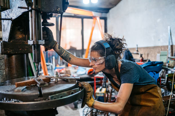 istock Young Woman Working On A Drill Press Machine In A Metal Workshop 2174169839