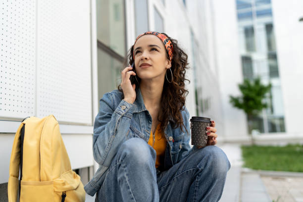 istock Young university student using mobile phone on stairs outdoors 2174172471