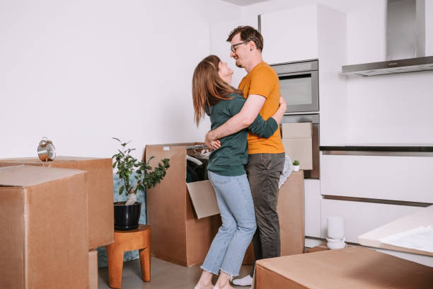 istock Happy Couple Embracing in New Home with Moving Boxes 2174172662