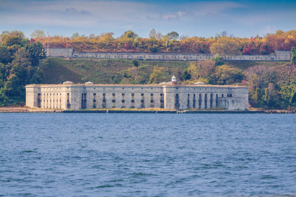 Historic Fort Wadsworth with Trees in Autumn Colors in Background, New York, NY, USA. It is situated next to the Foot of the Verrazano-Narrows Bridge on the Staten Island side.  Fort Wadsworth is a former United States military installation, which is on the Narrows that divides New York Bay into Upper and Lower halves, a natural point for defense of the Upper Bay and Manhattan. Prior to closing in 1994 it claimed to be the longest continually manned military installation in the United States. Canon EF 200mm f/4L IS USM Lens.