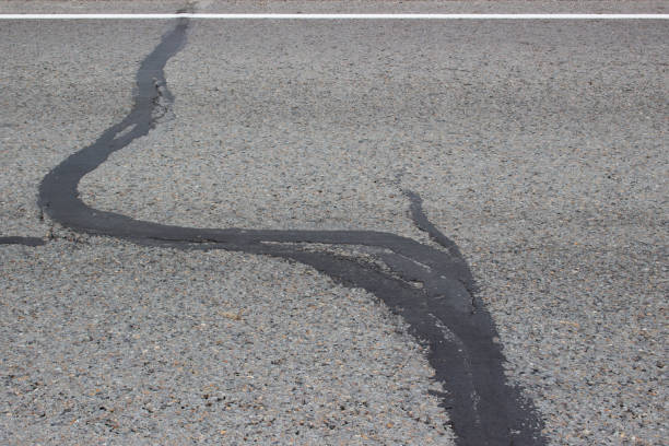 istock Crack in asphalt repaired with bitumen 2174178010