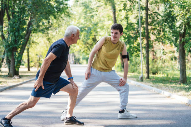 istock Two generations exercise in a sunlit green park area. 2174183560