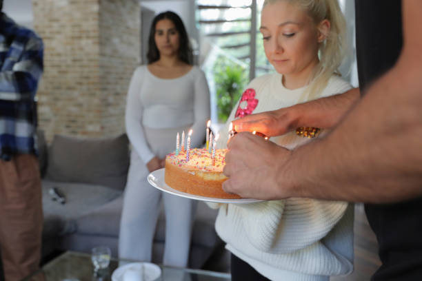 Birthday girl blowing candles on her birthday cake with her mother.