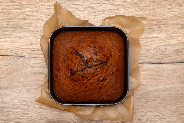 Baked cocoa cake lying on a square baking tray.