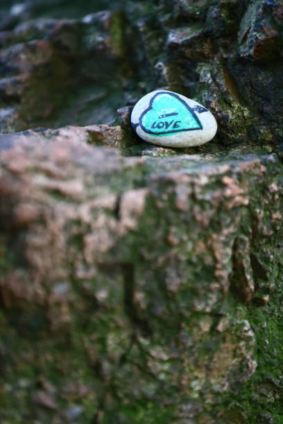 a small stone with a heart pierced by an arrow drawn on it on a rock