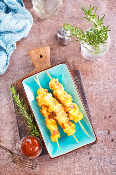 istock Chicken kebab skewers on a plate over light grey slate, stone or concrete background . 2174191025