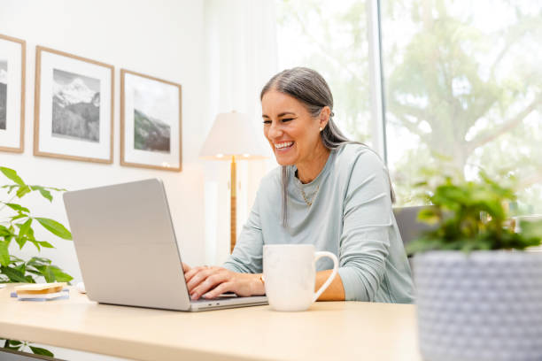 istock Mature female smiles while on a video call with her family 2174191939