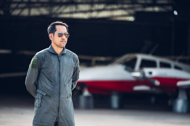 Pilot in uniform at airport. Asian Confident male pilot in uniform  and checking flight plan