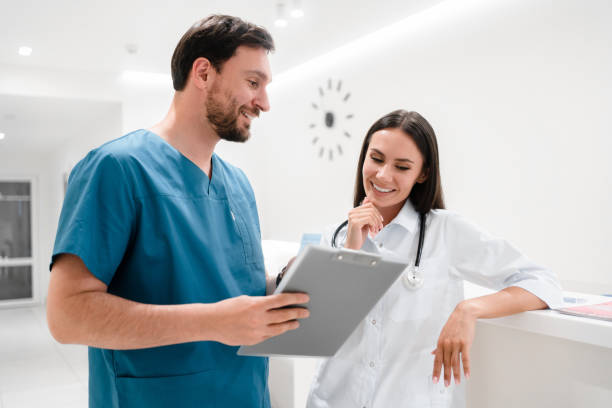 istock Beautiful young doctors are working with documents and smiling while standing in hospital hall. Medical group talking about support strategy, medicine and surgery teamwork in hospital 2174193638