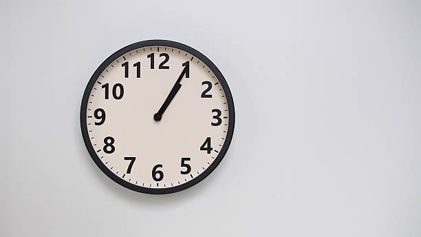 istock Classic Black-Edged Clock on White Background at 13.05/00.05 - Perfect for Time Management and Text Space 2174194238