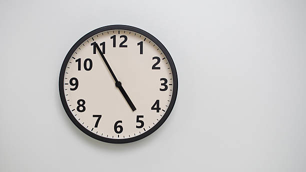 istock Classic Black-Edged Clock on White Background at 16.55 or 04.55 - Perfect for Time Management and Text Space 2174195727