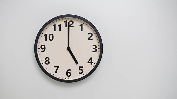 istock Classic Black-Edged Clock on White Background at 17.00 or 05.00 - Perfect for Time Management and Text Space 2174195738