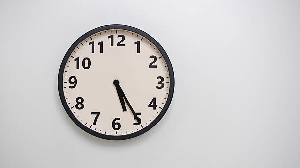 istock Classic Black-Edged Clock on White Background at 17.25 or 05.25 - Perfect for Time Management and Text Space 2174195775