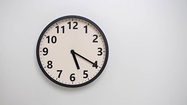 istock Classic Black-Edged Clock on White Background at 17.20 or 05.20 - Perfect for Time Management and Text Space 2174195783