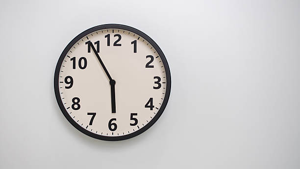 istock Classic Black-Edged Clock on White Background at 17.55 or 05.55 - Perfect for Time Management and Text Space 2174195794