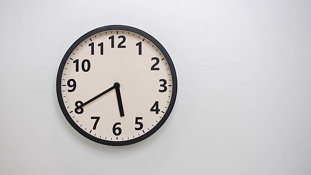 istock Classic Black-Edged Clock on White Background at 17.40 or 05.40 - Perfect for Time Management and Text Space 2174195824