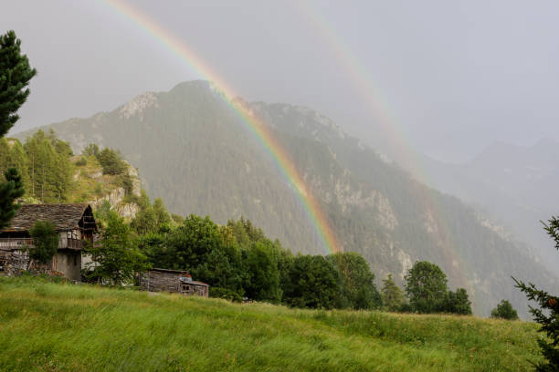 Fenilliaz, Aosta Valley, Italy - July 31, 2024: Double rainbow over a mountain village.