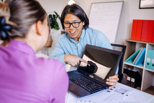istock Financial advisor working in office using laptop and talking with client showing figures 2174197423