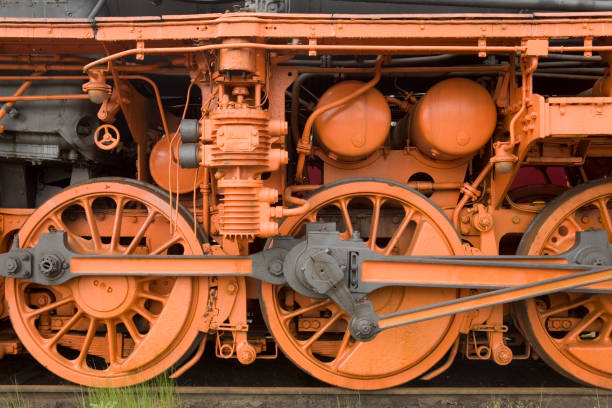 Taken in a railway museum in Holland, this lovingly restored locomotive has been given a bright orange colour scheme and the focus is on the driving wheels and drive mechanism