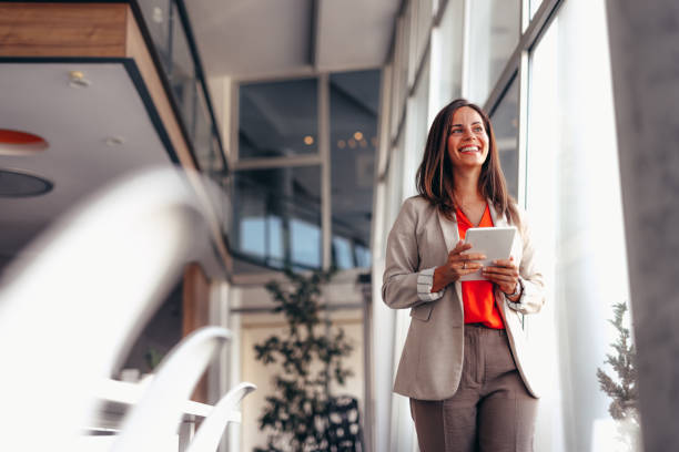 istock Smiling businesswoman in modern office holding tablet 2174198300