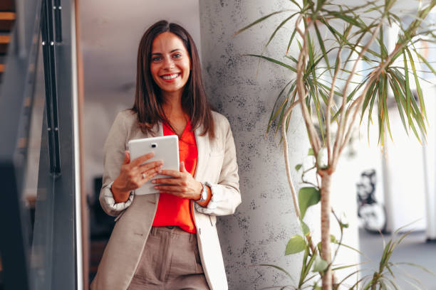 istock Smiling businesswoman in modern office holding tablet 2174198445