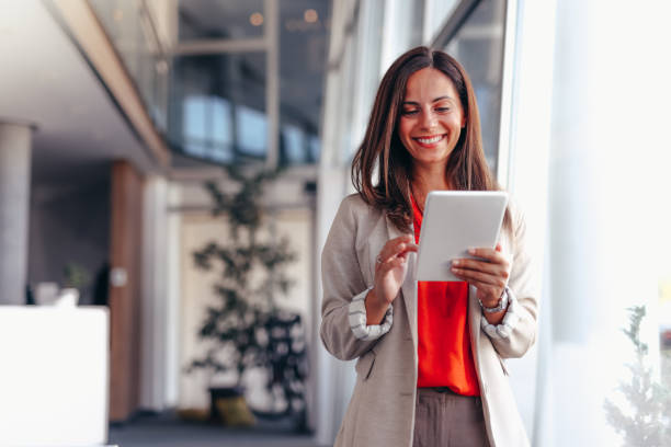 istock Smiling businesswoman in modern office holding tablet 2174198839