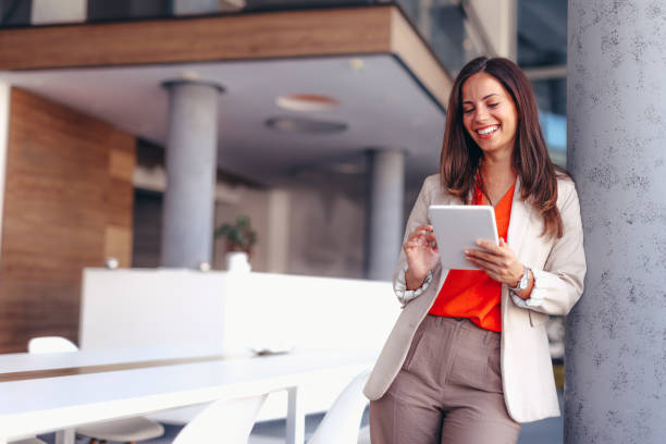 istock Smiling businesswoman in modern office holding tablet 2174199190