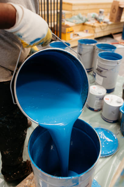istock Construction worker pouring blue epoxy resin for rubber flooring 2174200153
