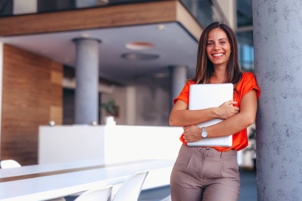 istock Confident Business Woman Holding Laptop in Modern Office 2174200973