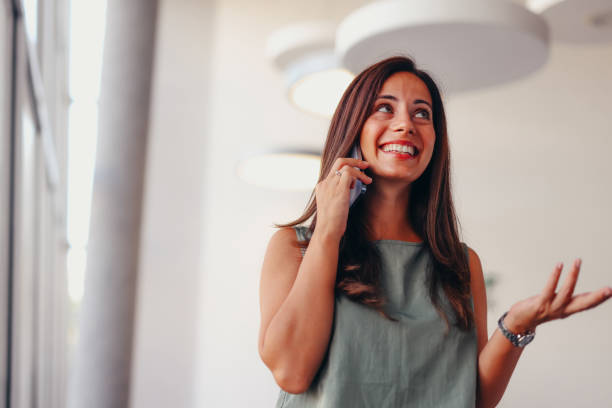 istock Smiling businesswoman using phone in office 2174201578