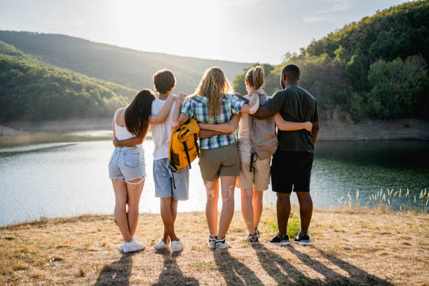 istock Friends embracing while standing in front of a lake 2174206983