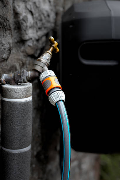 Insulated waterpipe leading to External 1/2 inch Brass T-handled Water Tap and Garden Hose.  The focus of the image is on the connection point where the hose meets the pipe.