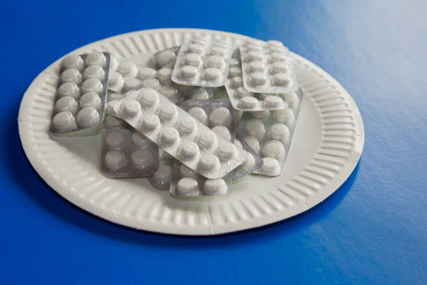 istock Blisters with white tablets on a white paper plate on an overall blue background, close-up, daily dose of medicine, taking medicine, high dose of medicine, medicine instead of food, medical diet 2174208625