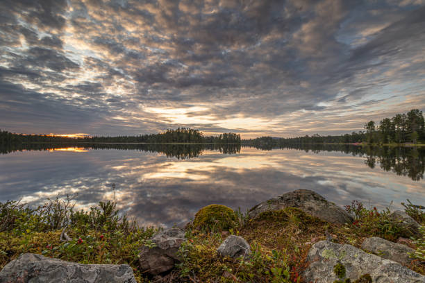 istock Rocks and heath by a mirror-smooth Swedish lake under an imposing cloud cover 2174214126