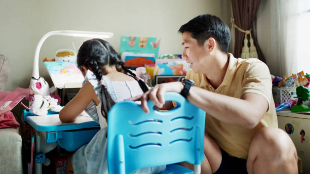 istock Father assisting cute little daughter doing homework 2174223797
