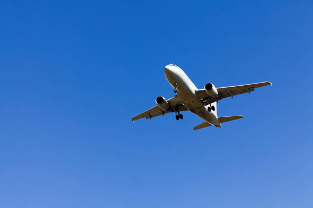 istock Low Flying Jet Plane In Clear Blue Sky With Landing Gear Down 2174230536