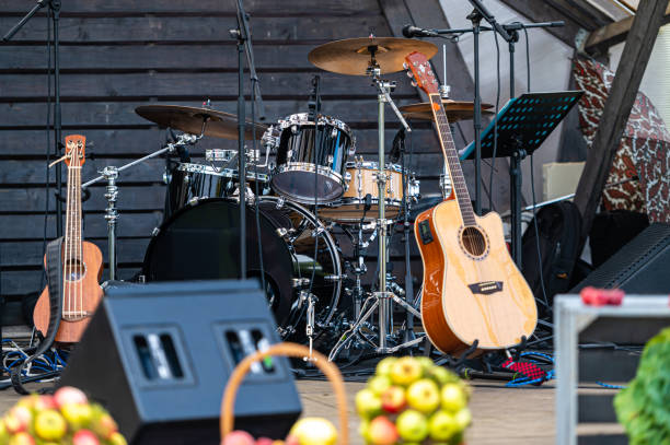 A stage is prepared with drums and guitars, awaiting the start of a live music event.